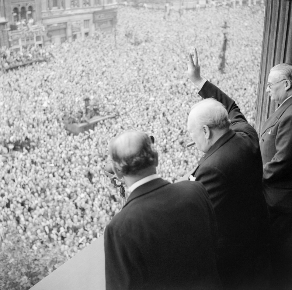 Premier Winston Churchill pozdrawia tłum zgromadzony na ulicy Whitehall w Londynie 8 maja 1945 roku, pokazując V – symbol zwycięstwa [fot. wikipedia/domena publiczna]